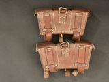 three pieces of brown leather luggage sitting on top of a gray surface