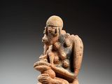 une vieille figurine représentant un homme tenant un bébé dans ses bras