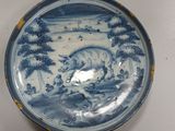 a blue and white plate with a cow on it