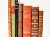 plusieurs vieux livres sont alignés sur une surface blanche