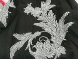 black jacket with silver embroidery on the back of it