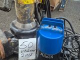 une photo d'une pompe à eau bleue et noire à côté d'un bidon bleu