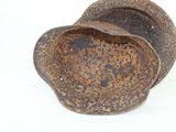 a rusted metal bowl sitting on a white surface