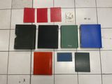 a bunch of different colored books sitting on top of a tiled floor