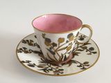 a pink cup and saucer on a white table