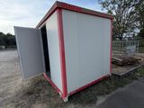 a small white and red building on the side of the road