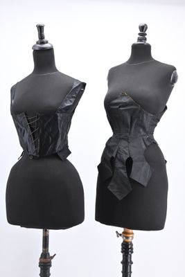 two black mannequins with black leather bows on them
