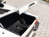 a white car with its hood open sitting on a brick road