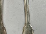 two spoons that are sitting next to each other on a table