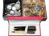 a box with a pen, watch, and other items in it