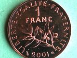 a close up of a one franc coin on a green surface