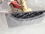 a plastic container with a doll in it on a table