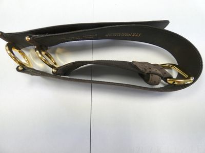 brown leather belt with gold hardware on a white surface