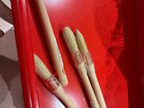 une boîte rouge contenant trois bâtonnets en bois
