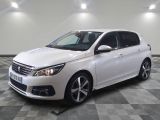 la voiture blanche est garée sur un sol en damier dans le garage