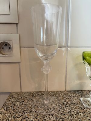 un verre à vin posé sur un plan de travail, à côté d'un autre verre à vin