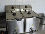 two deep fryers sitting on the counter in the kitchen