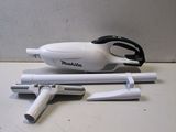 a small white vacuum on a table next to a pair of scissors