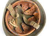 an overhead view of a military helmet with leather straps and a metal buckle