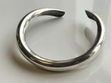 a close up of a silver bracelet on a white surface