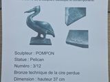 plaque of a pelican and a bronze statue of a pelican on a table