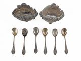 six silver spoons and a bowl with spoons on a white surface