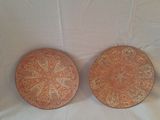 Il s'agit de deux assiettes ornées de motifs, posées sur une surface blanche.