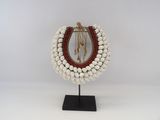 a white and red beaded necklace on a black stand