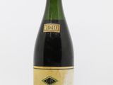 une bouteille de vin avec une étiquette, posée sur une surface blanche
