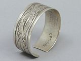 a close up of a silver bracelet on a gray surface