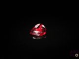 un gros plan d'un diamant rouge en forme de cœur sur une surface noire
