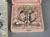 a silver plate with a spoon and a spoon in a box