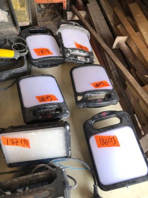 Plusieurs téléphones portables sont alignés sur une table dans un entrepôt