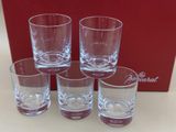 four empty glasses sitting on a table next to a red box
