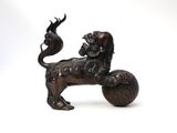 a bronze statue of a lion on a ball