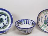 trois pièces de poterie bleue et blanche posées sur une table