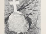 black and white photograph of a rock with a cross on it