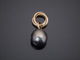 a black pearl and gold ring pendant on a black background