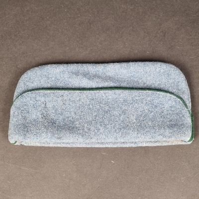 un gros plan sur un petit sac gris posé sur une surface marron