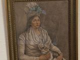 a painting of a woman holding a cat on a wall