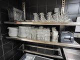 une cuisine avec beaucoup de vaisselle et de verres sur les étagères
