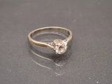 une bague sertie d'un diamant, posée sur une table