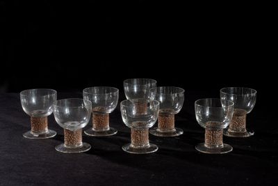 six wine glasses are lined up in a row on a black surface