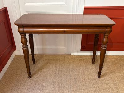 a wooden table with a glass top on a carpeted floor