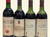 three bottles of red wine are lined up on a white surface