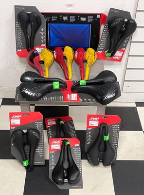 many different types of saddles on display in a store