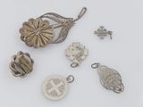 several silver jewelry items are arranged on a white surface