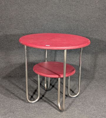 une table rouge sur laquelle se trouvent deux tabourets rouges