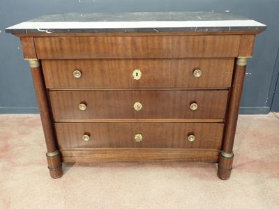 an antique chest of drawers with marble top and brass handles