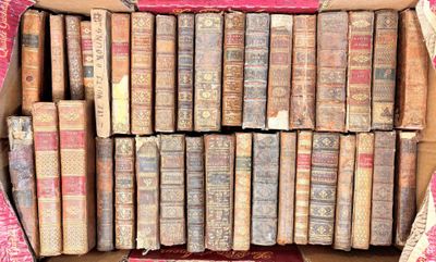 de nombreux vieux livres dans une boîte en carton posée par terre